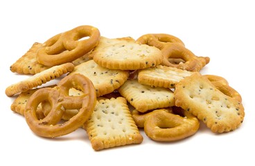 A small pile of party snacks crackers and pretzels isolated on a white background