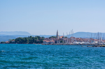 Fototapeta na wymiar Touristic view of Izola Slovenia old fishing town historic center with church tower and marina surrounded with sea
