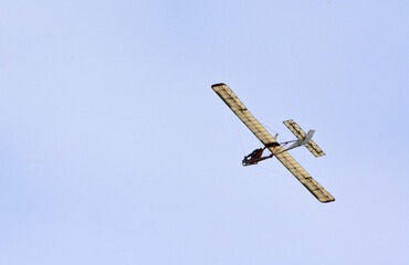 Vintage  Schneider Glider in flight  blue sky and clouds.