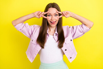 Photo portrait smiling girl showing v-sign gesture licking lips isolated bright yellow color background