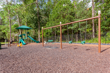 Playground with a swing set and climbing area with slides 