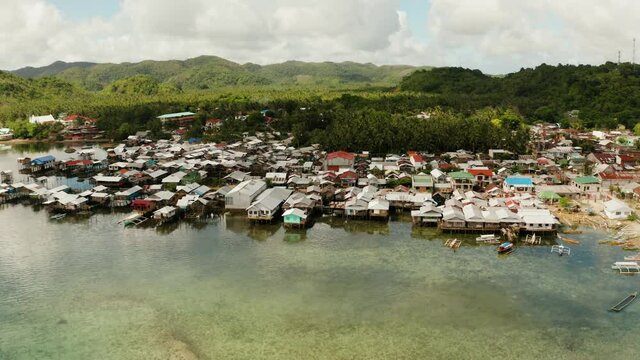 Village of stilt houses built over the sea, top view. Dapa, Siargao, Philippines.