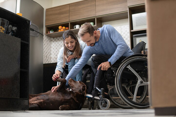 disabled couple playing with pet and enjoying home.