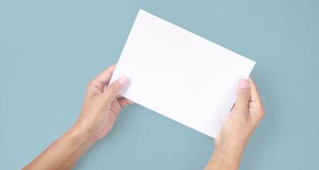 Hands holding paper blank for  letter paper