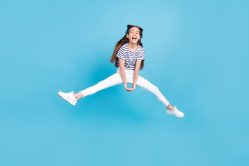 Fototapeta na wymiar Full body photo of young excited girl happy positive smile jump up isolated over blue color background