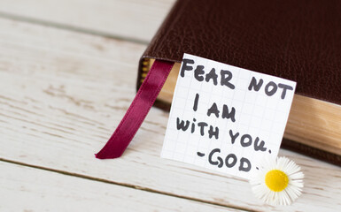 Fear not, I am with you - God, closed Holy Bible with a handwritten inspiring note. Christian...