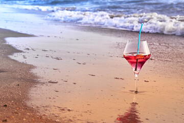 Wine glass with a cocktail by the sea.