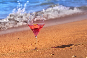 Wine glass with a cocktail by the sea.