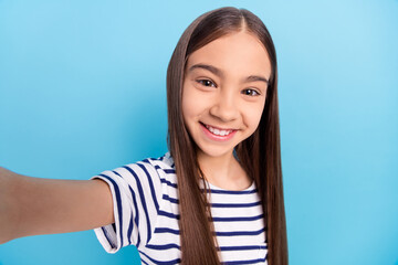 Fototapeta premium Photo portrait little girl wearing striped shirt smiling taking selfie isolated pastel blue color background
