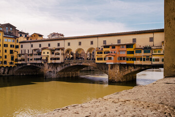 Fototapeta na wymiar River Arno and famous bridge Ponte Vecchio in the sunny afternoon in Florence, Tuscany, Italy