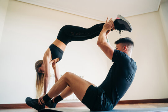 Flexible couple doing acroyoga exercise