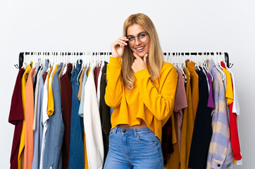 Naklejka na ściany i meble Young Uruguayan blonde woman in a clothing store with glasses and smiling