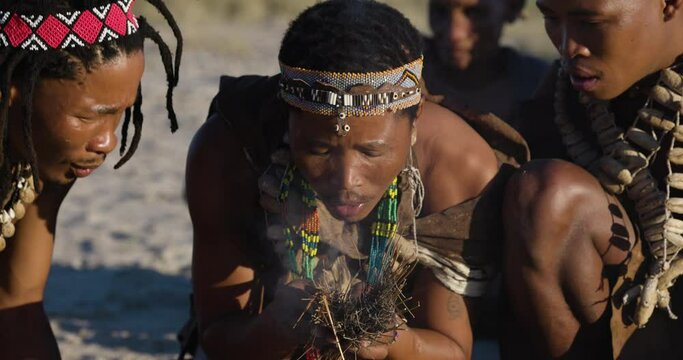Close-up portrait view of tribal San people (Bushmen) making a fire in the traditional way