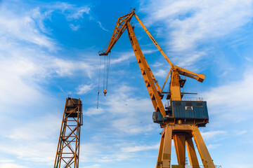 Harbor crane on a background of blue sky, bottom view.