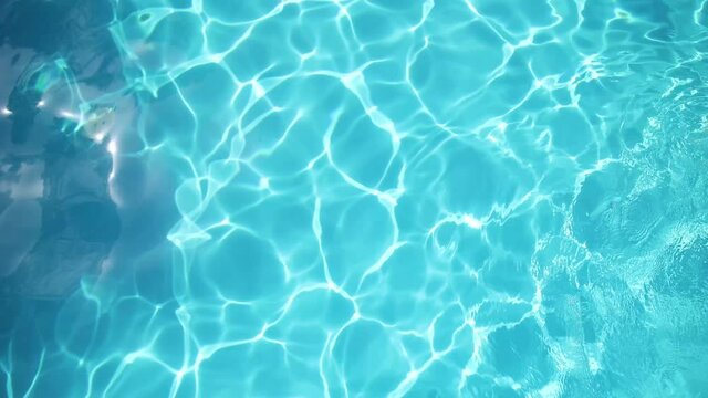 wave of water on a sunny day in a blue pool in summer