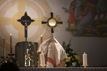 A priest holding a monstrance in the Church  - obrazy, fototapety, plakaty