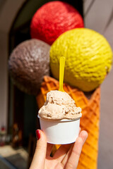 Ice cream in a paper cup. Sweets and weekend walks