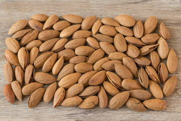 Almonds, almonds with shell on a wooden table background.