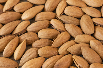 Almonds, almonds with shell on a wooden table background.