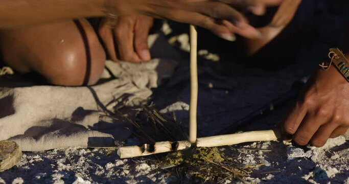 Close-up portrait view of San people (Bushmen)using a fire starter stick in traditional way