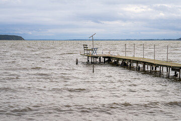 A wooden pier with a bench on the coast of the Krumminer Wiek in Neeberg, Mecklenburg-Western...
