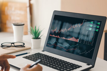 Businessmen work with stock market investments using laptops to analyze trading data. desktop...