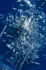 decorative glass perfume bottle underwater on colorful background 