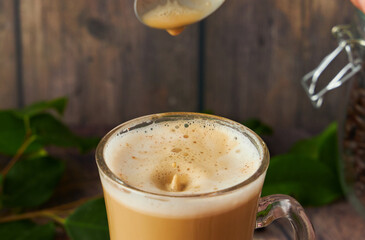  cup of cappuccino coffee with foam on rustic background