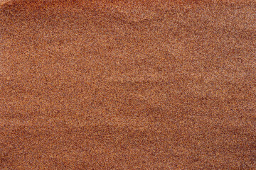 Fototapeta premium Sandpaper texture background where you can see the red-brown sand grain pattern on the sandpaper, suitable as a background for inserting text. Copy Space for designers to use on sandpaper.