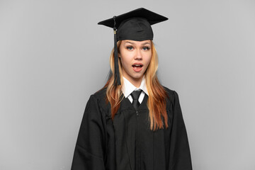 Young university graduate girl over isolated background with surprise facial expression