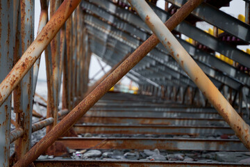 Rusty support pipes of the sports field stands. Construction fittings