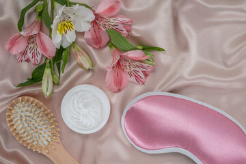 daily skincare before bedtime, moisturizer or nourishing cream, serum and sleep mask on a silk background