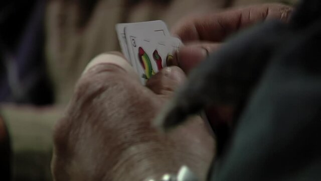 Group of Men playing Truco, a Typical trick-taking Card Game in Argentina. Close Up.