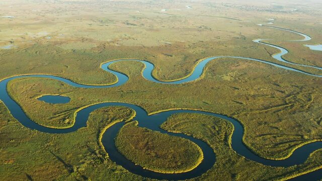 Spectacular aerial fly over view of the beautiful scenic curving patterned waterways and lagoons of the Okavango Delta