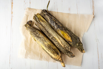 Spoiled moldy food. Cobs of corn with mold on white background.