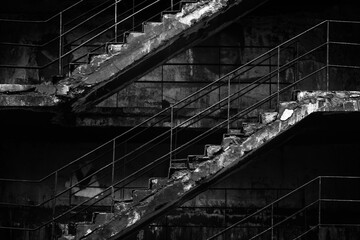 Obraz premium Old concrete staircase with rusty railing in black and white.