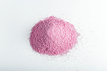 Pink dried strawberries or  beetroots powder on white background.  Textured paint in powder form for childrens creativity. Fruit starch,  jelly, gelatin cooking ingredients.