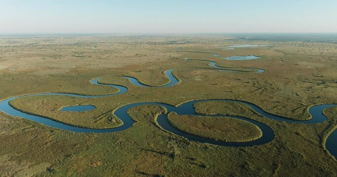 Spectacular aerial fly over view of the beautiful scenic curving patterned waterways and lagoons of the Okavango Delta
