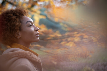 Serene thoughtful young woman in autumn park