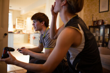 Teenage boys playing video game at home