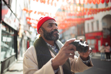 Male tourist with digital camera on city street