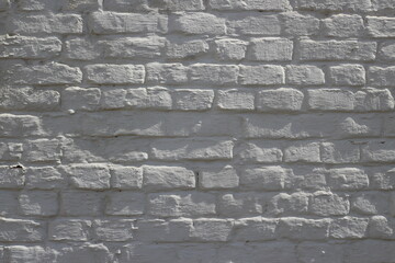 a whitewashed old brick wall, the light of the sun falls from the side