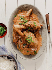 Lamb shank meal on white picnic table