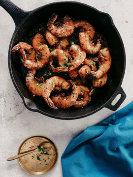 Barbeque shrimp in cast iron skillet on white table