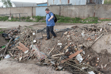 Obraz premium a man goes down into a hole with garbage