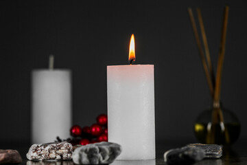 Burning aromatic candle and plants on table.