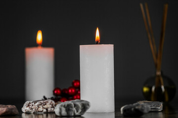 Burning aromatic candle and plants on table.