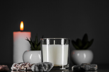 Burning aromatic candle and plants on table.