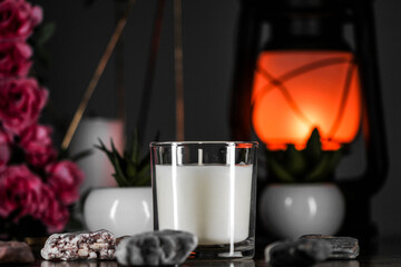 Burning aromatic candle and plants on table.