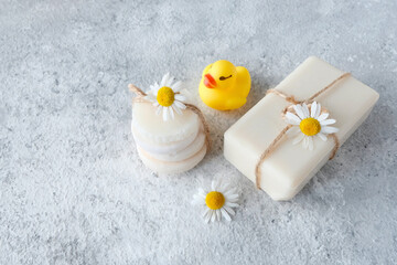 Fototapeta na wymiar Baby soap, medicinal chamomile. Baby healthy body hygiene concept. Duckling for bathing, toy